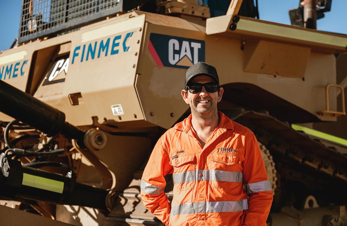 Daniel Finch standing in front a Cat Bulldozer