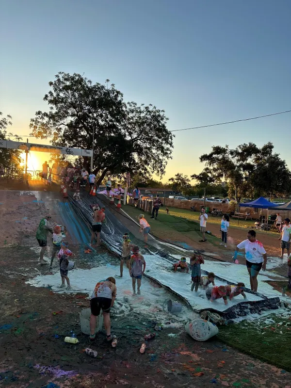 Kids and adults getting wet on the soapy water slide