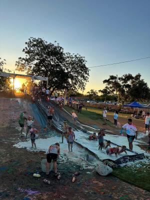 Kids and adults getting wet on the soapy water slide