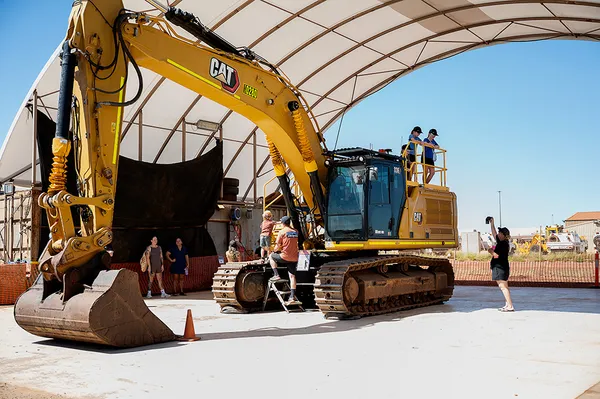 Large Cat Excavator with kids and families around